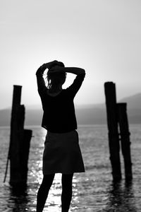 Rear view of man standing against sea