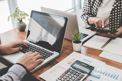 Midsection of man using laptop on table