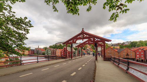 Road by built structure against sky