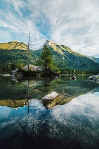 Scenic view of lake by mountains against sky