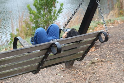 Rear view of people sitting on swing in park