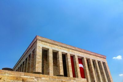 Low angle view of turkish flag on anitkabir against blue sky