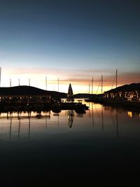 Silhouette sailboats in lake against sky during sunset