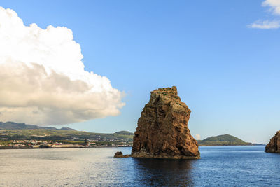 Rock formation in sea against sky