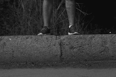 Low section of woman standing on wall