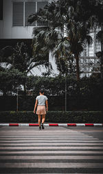 Rear view of man walking on road