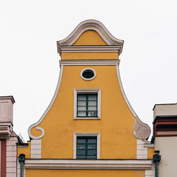 Low angle view of yellow building against sky