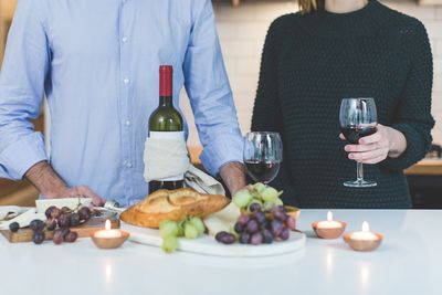 Midsection of woman having food at table