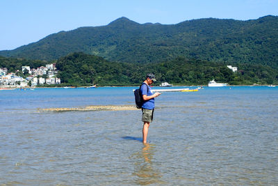 Rear view of woman standing at beach