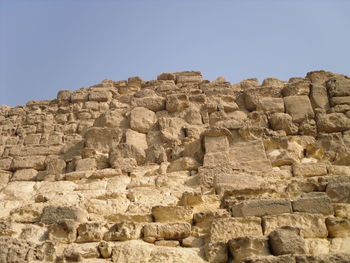 Low angle view of old ruins against clear sky - pyramids giza