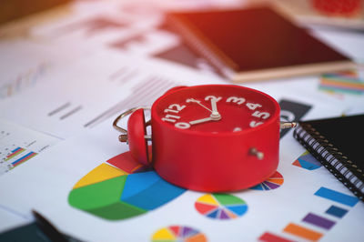 Work planner with red clock time on desk with business chart graph.