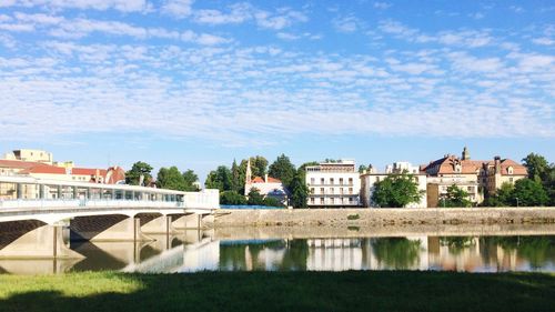 Reflection of houses in water against sky