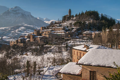Townscape by snow covered mountain against sky