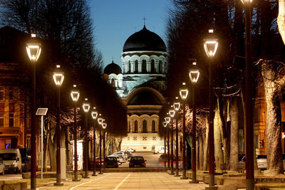 Street amidst illuminated buildings in city at night