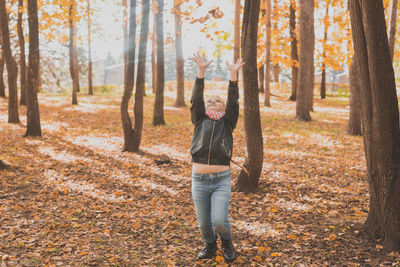 Full length of man standing by tree in forest during autumn