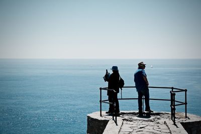 Silhouette of people standing on pier