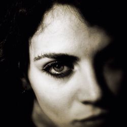 Close-up portrait of young woman over black background