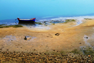 Abandoned boat on beach against sky