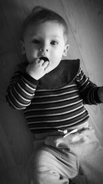 High angle portrait of cute baby girl lying on floor at home