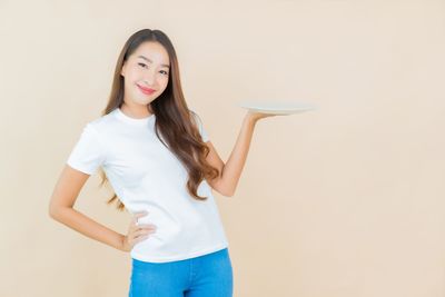 Portrait of a smiling young woman against white background