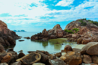 Rocks by sea against sky