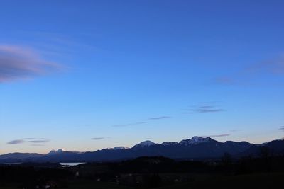 Scenic view of silhouette mountains against blue sky at sunset