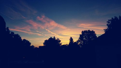 Silhouette trees against sky at sunset