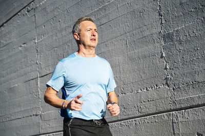 Senior retired man runs and performs exercise