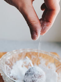 Close-up of hand sprinkling powder sugar 