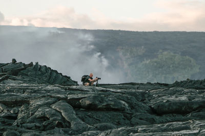 Man standing on mountain against sky