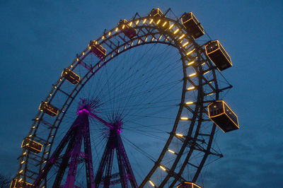 Low angle view of illuminated ferris wheel against sky