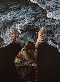 Low section of man sitting on rock