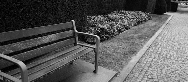 Empty bench on footpath