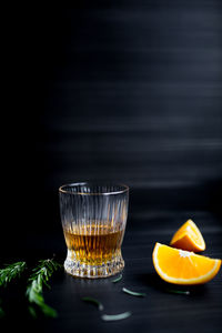 Glass with whiskey and orange.