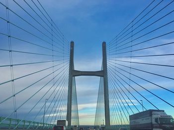 Low angle view of suspension bridge against blue sky