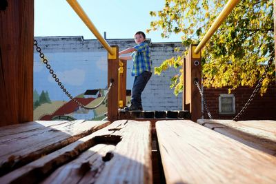 Side view full length of boy standing by railing