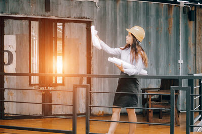 Side view of woman standing by railing