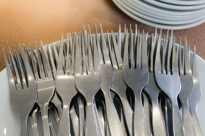High angle view of forks in plate on table