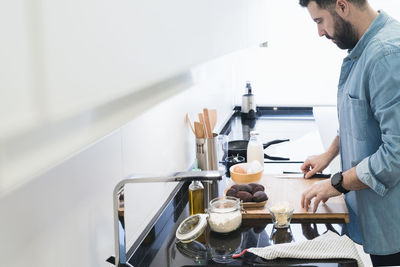 Man cooking in the kitchen in a denim shirt