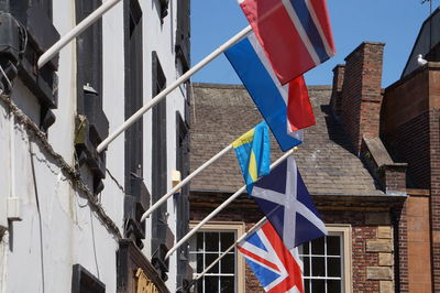 Low angle view of flags hanging against buildings