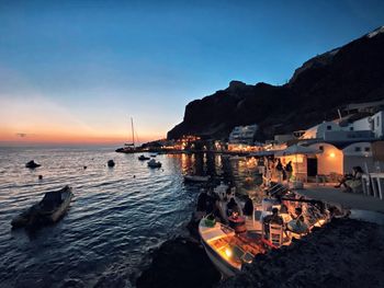 Panoramic view of sea and buildings against sky at sunset