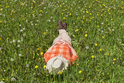 Senior hiker napping at meadow on sunny day