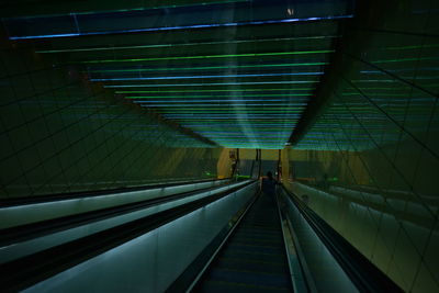 Escalator in illuminated underground walkway