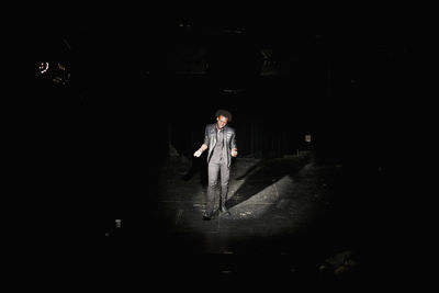 Full length portrait of man standing in the dark