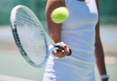 Midsection of man playing tennis