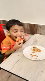 Boy eating food on table