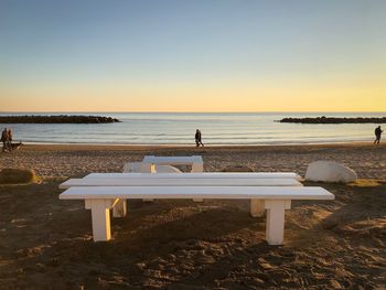 Scenic view of beach against clear sky during sunset