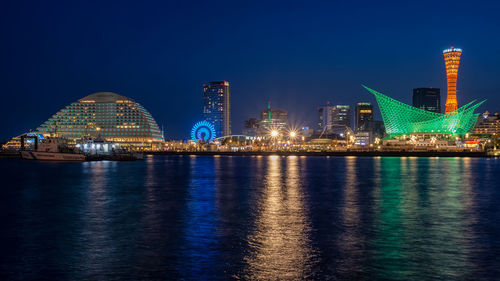 Illuminated city buildings against sky at night