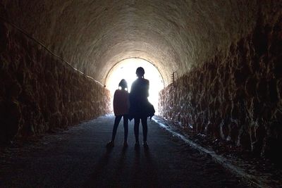 Siblings standing in tunnel