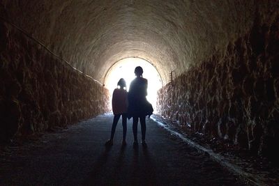 Rear view of woman walking in tunnel